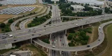 White House Infrastructure Plan 2.0: $500B Investment by 2026 Modern highway interchange with renewable energy infrastructure, symbolizing the White House's National Infrastructure Plan 2.0 investment.